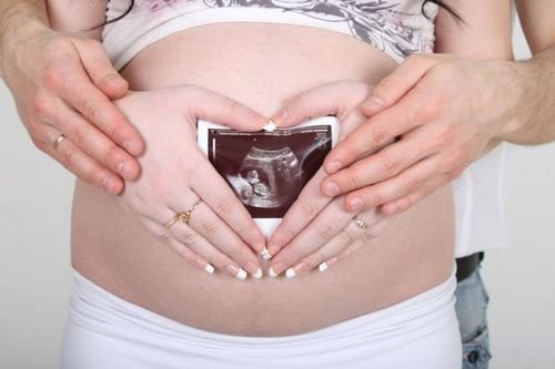 Беременная женщина с УЗИ снимком плода
